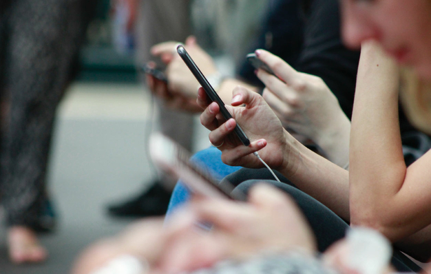 Mehrere Menschen besuchen eine Single Page Webseite auf ihrem Smartphone