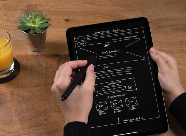 Ein Mitarbeiter von Inscript zeichnet eine Skize einer neuen Webseite auf ein iPad